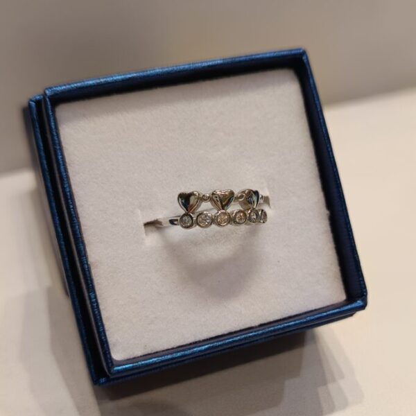 Anillo con hilera de circonias con engarce inglés y corazónes