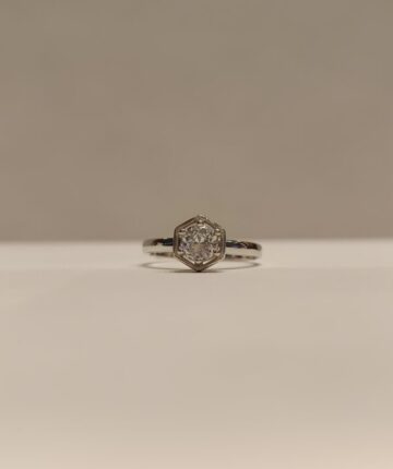Anillo con circonia central en base hexagonal y engarce de 6 grifas