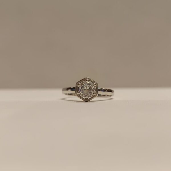 Anillo con circonia central en base hexagonal y engarce de 6 grifas