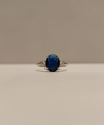 Anillo con circonia grande azul al centro y circonia pequeña blanca a los lados